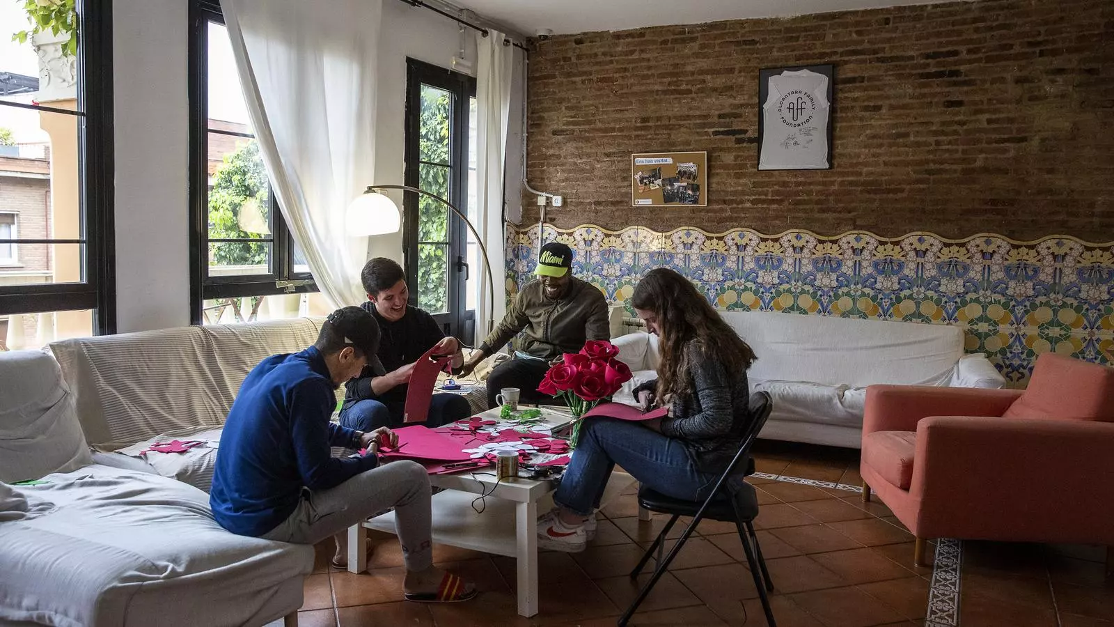 Joves fent treballs manuals a la sala de l'Alcantara Family Foundation, al barri del Putxet de Barcelona.