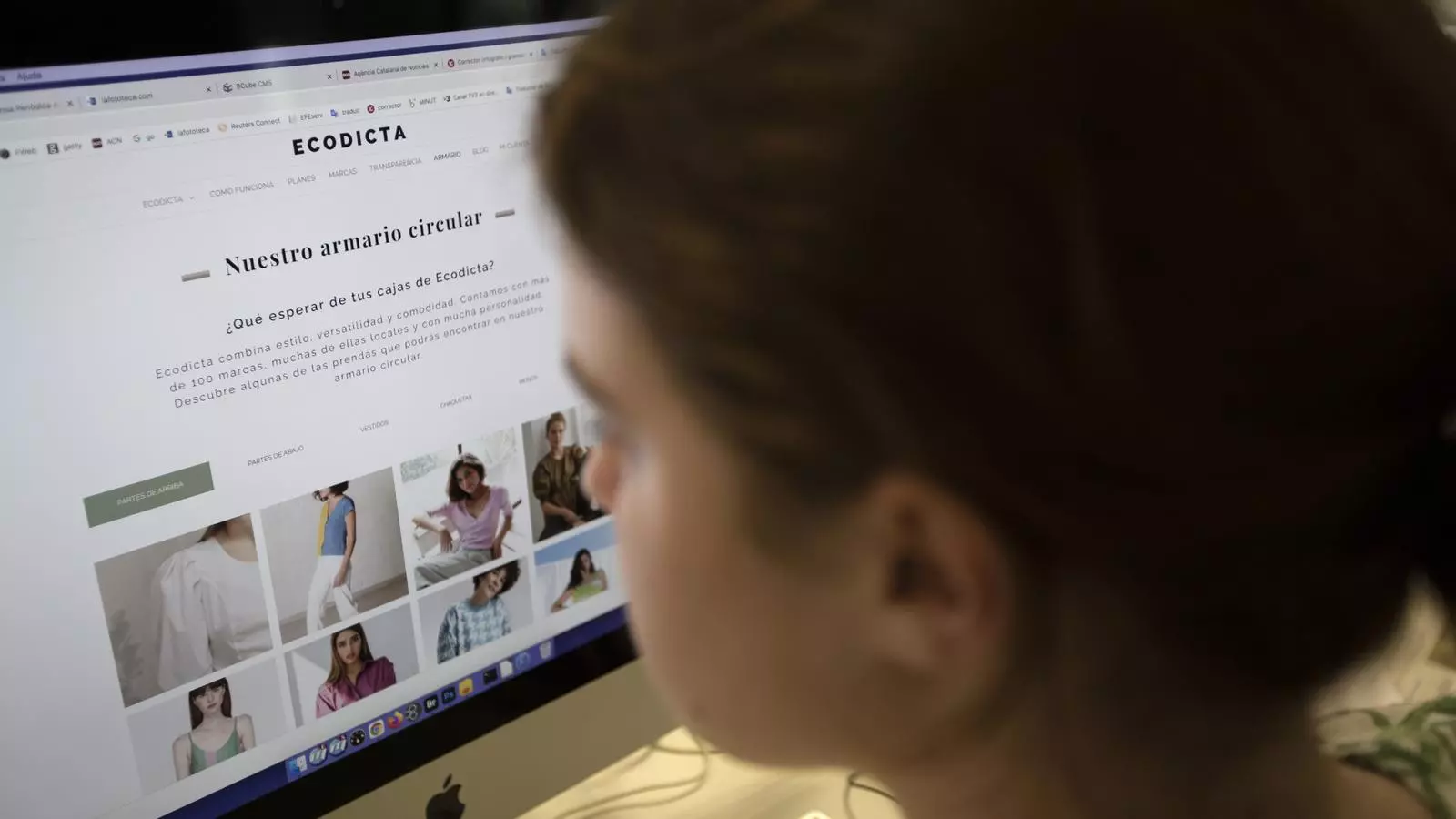 Una chica mira un portal de alquiler de ropa