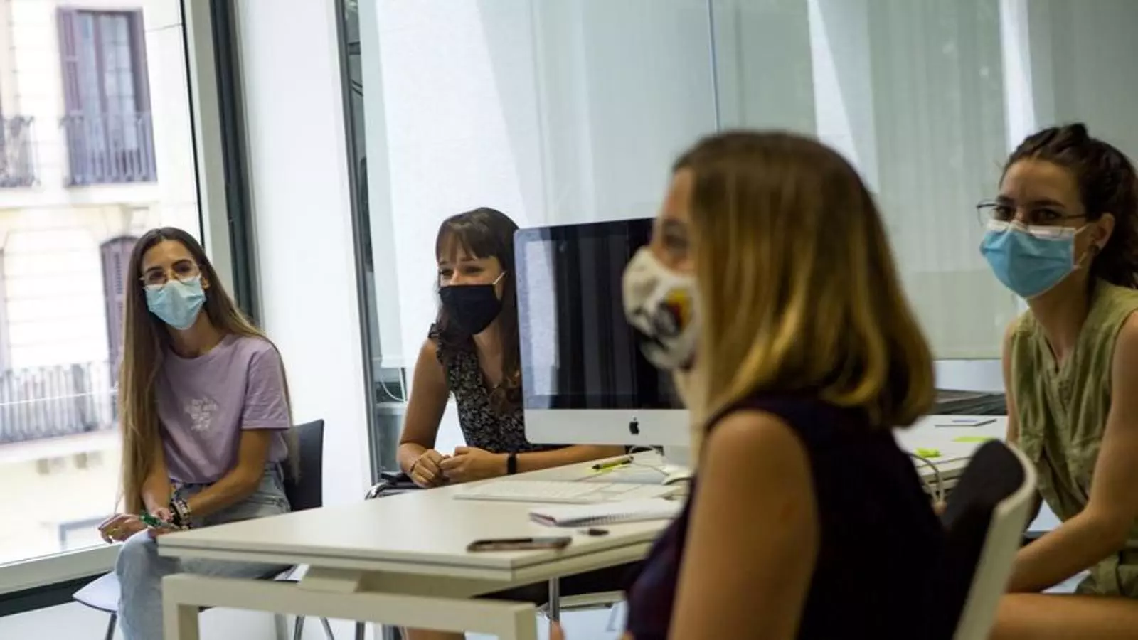 Trabajadoras con mascarilla a su puesto de trabajo