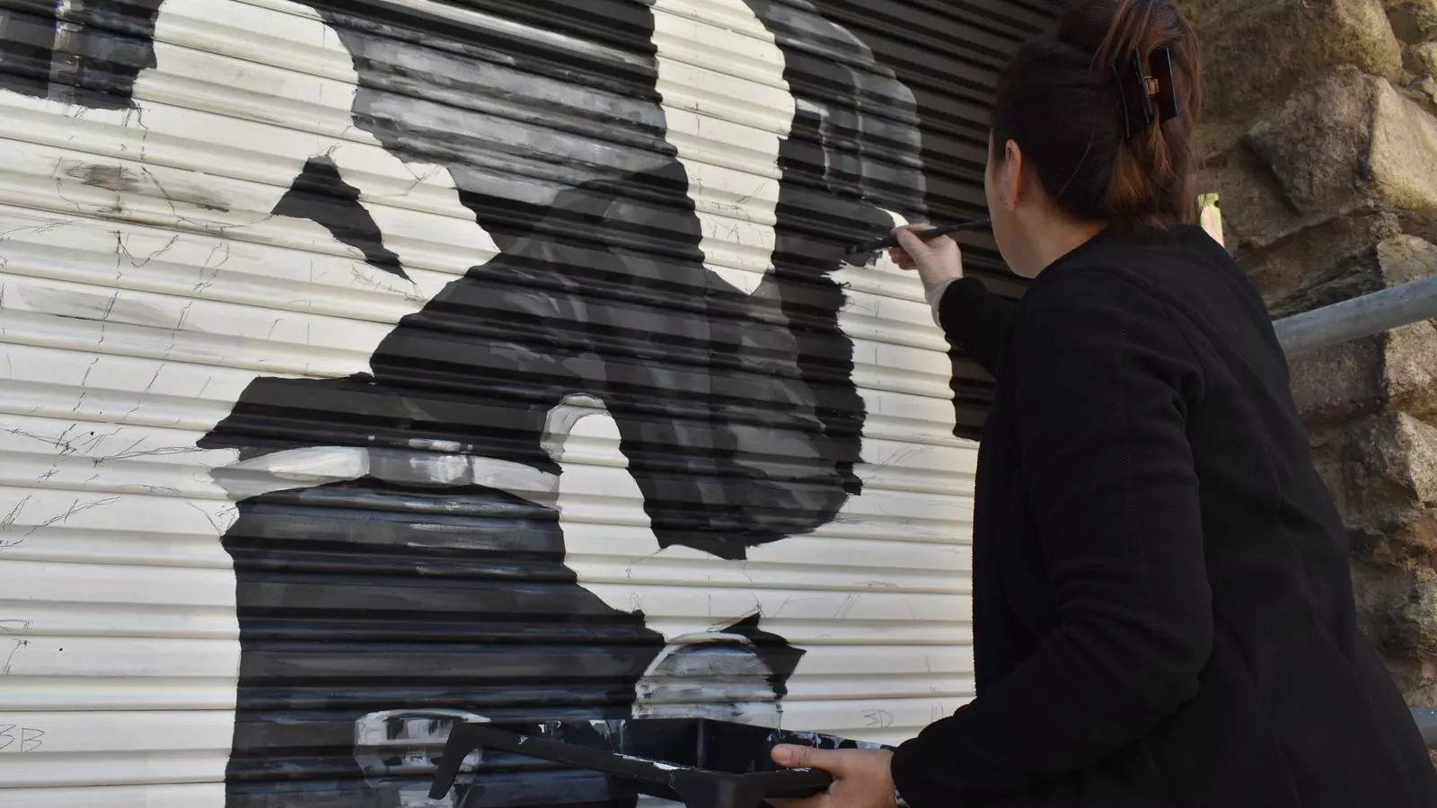 L'autora dels murals, Samantha Bosque, en pinta un.