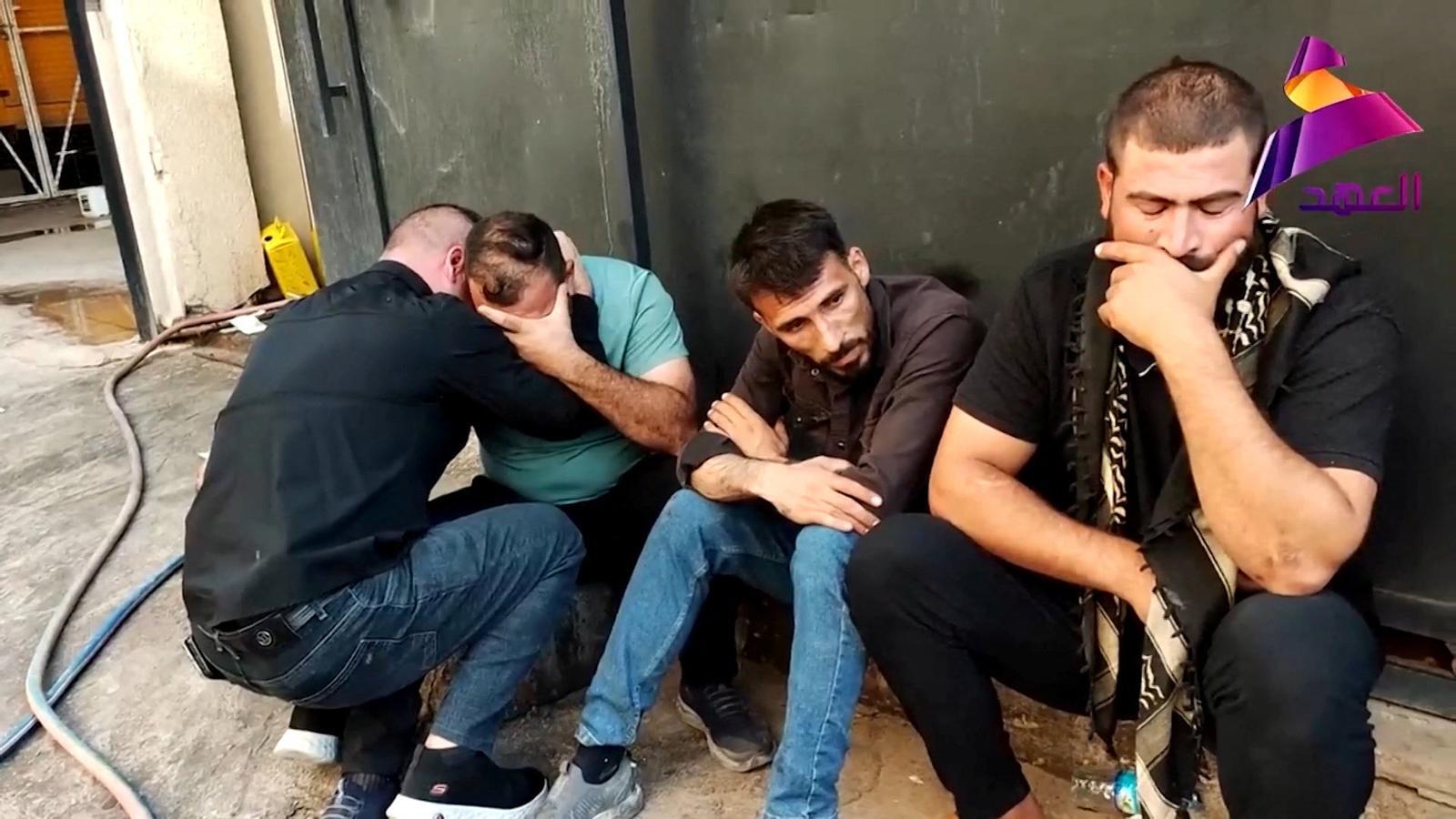 Un grupo de hombres cerca del Hospital General de Al-Hamdaniya, después del ataque que ha causado al menos veinte muertos y una treintena de heridos.