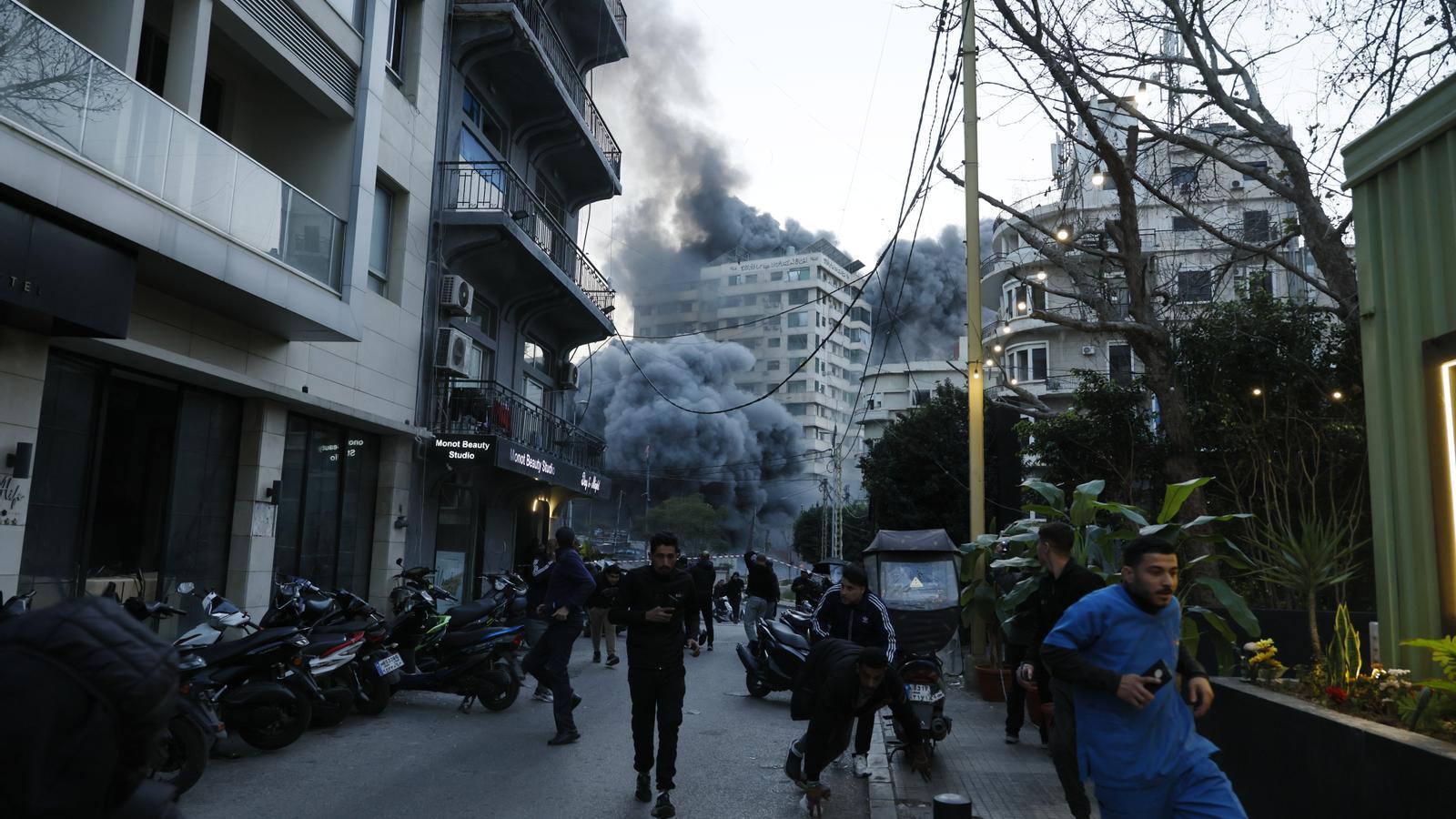 La gente intenta huir de la zona en la que Israel ha atacado un edificio en el barrio de Bashura de Beirut este jueves.