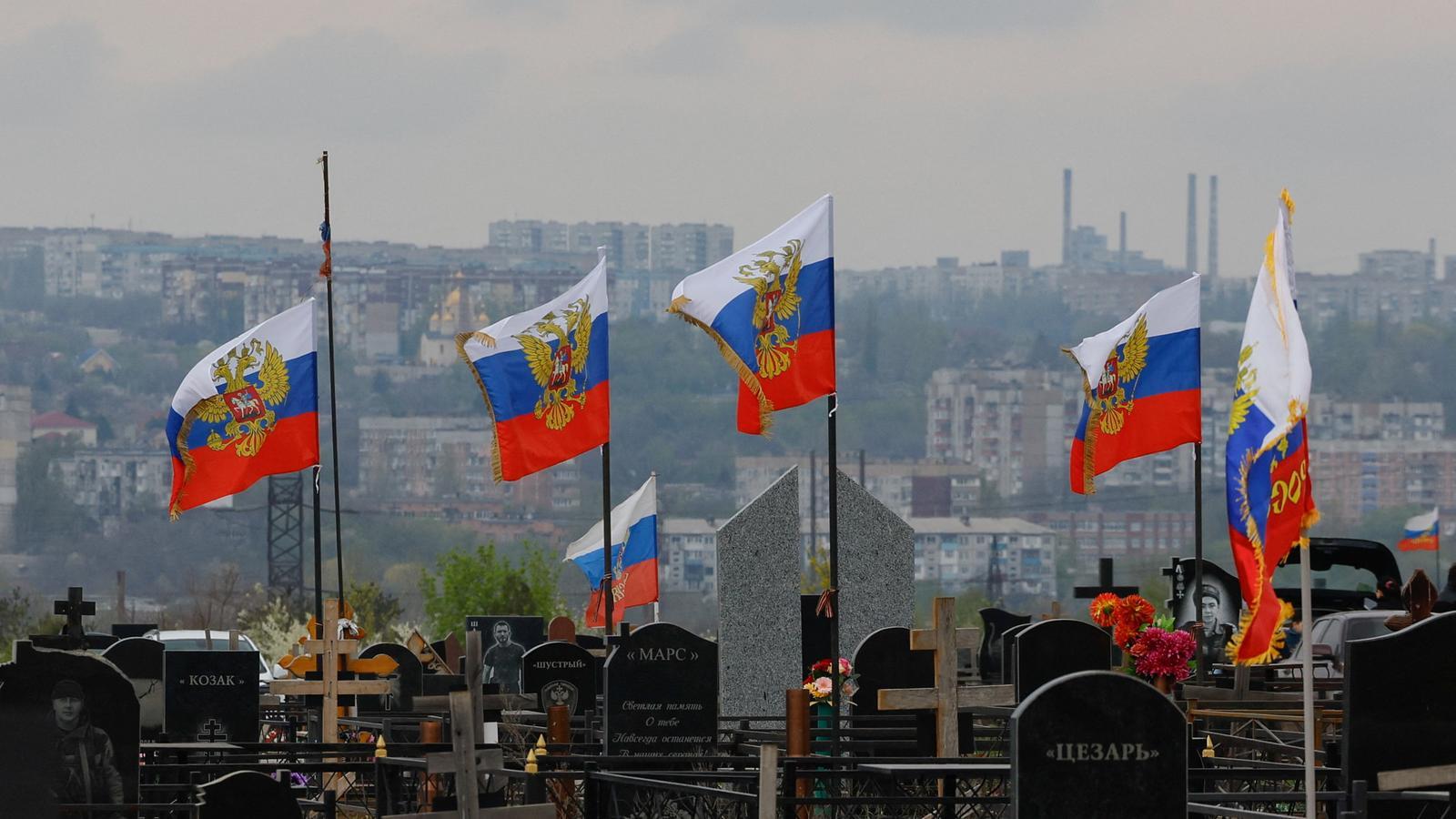 Flags over the graves of Russian soldiers killed during the conflict between Russia and Ukraine, in a cemetery on the outskirts of Donetsk.