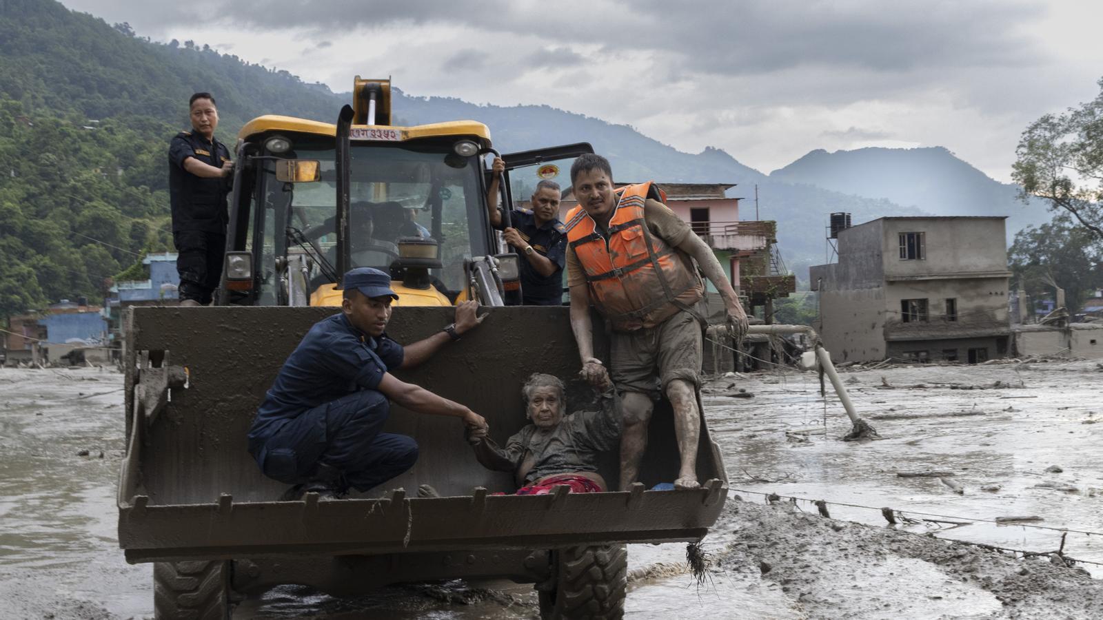 Rescue teams transport an elderly woman rescued from a nursing home in Devighat, Nepal.