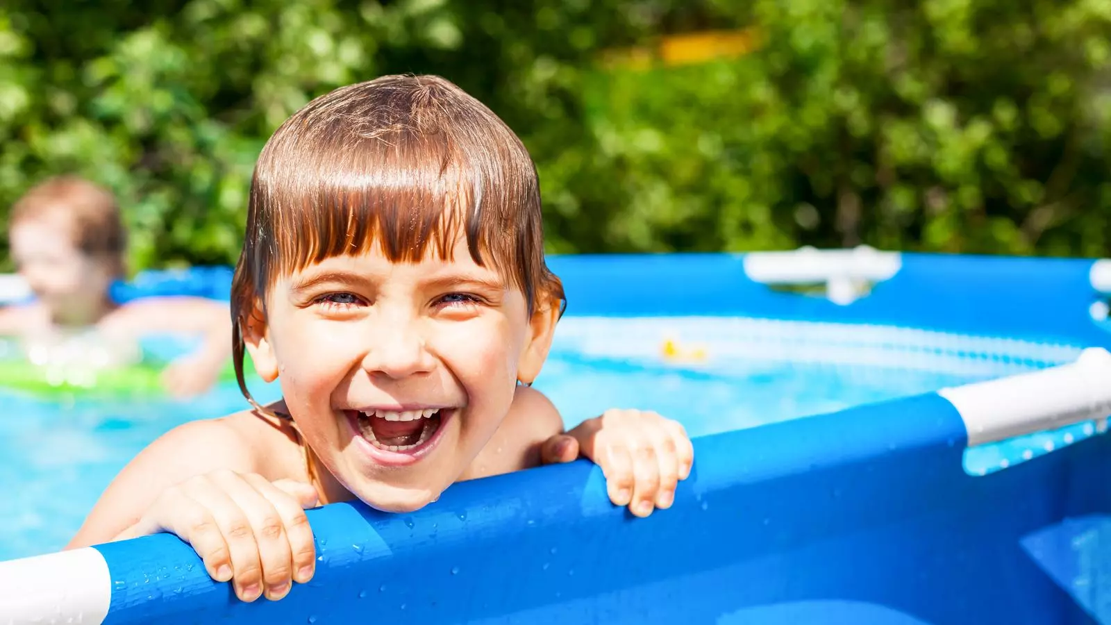 Un nen jugant en una piscina desmuntable