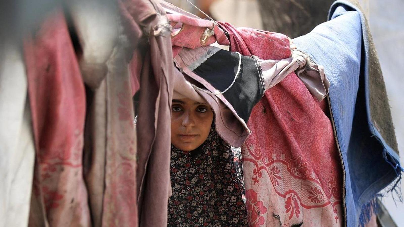 A Palestinian woman takes shelter in a tent camp in a photograph taken on August 17, 2025.