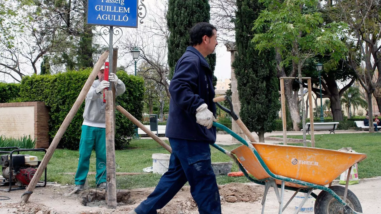 Operaris municipals durant la reposició del cartell del passeig Guillem Agulló als jardins de Vivers de València