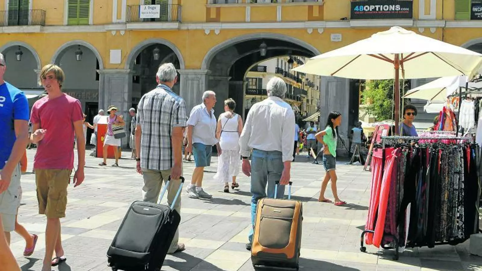 Turistes amb les seves maletes per la plaça Major de Palma