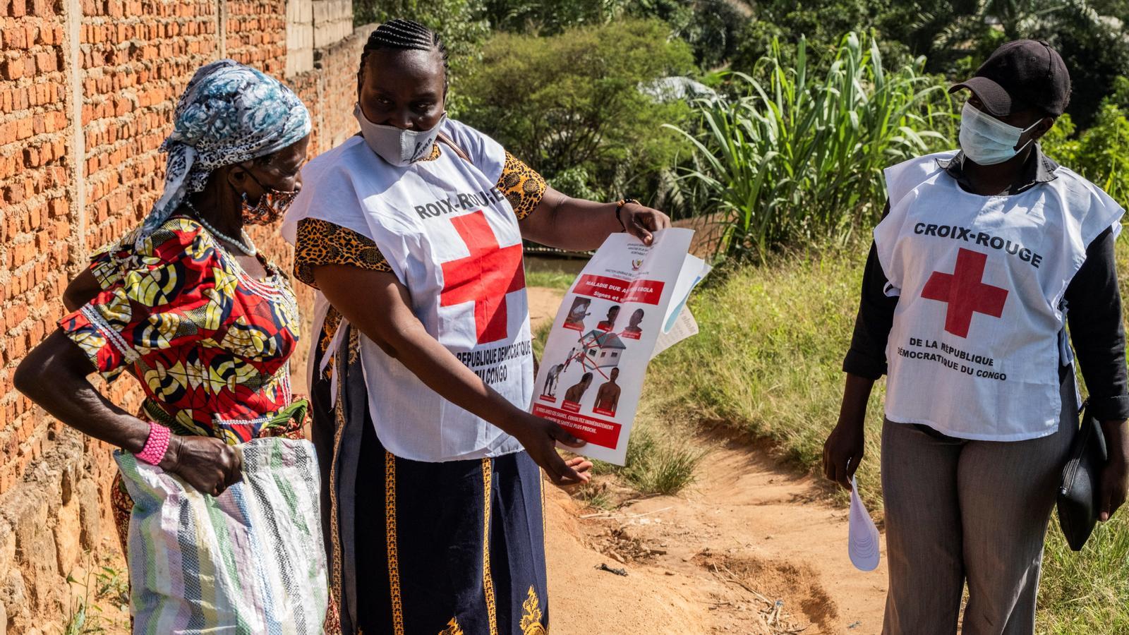 Trabajadoras de la Cruz Roja dan indicaciones sobre el Ébola a una vecina, en el Congo.