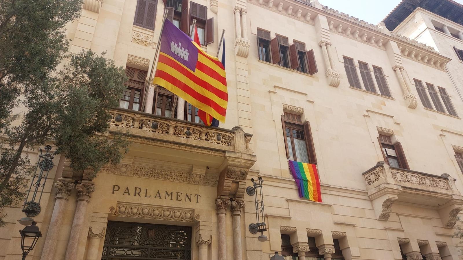 La bandera LGTBI colgando de la fachada del Parlament.