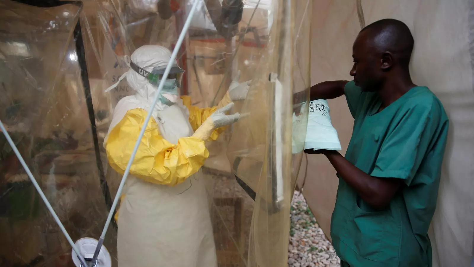 Un sanitari totalment protegit per evitar esquitxades i contacte amb l'Ebola es prepara per entrar a l'espai dels pacients