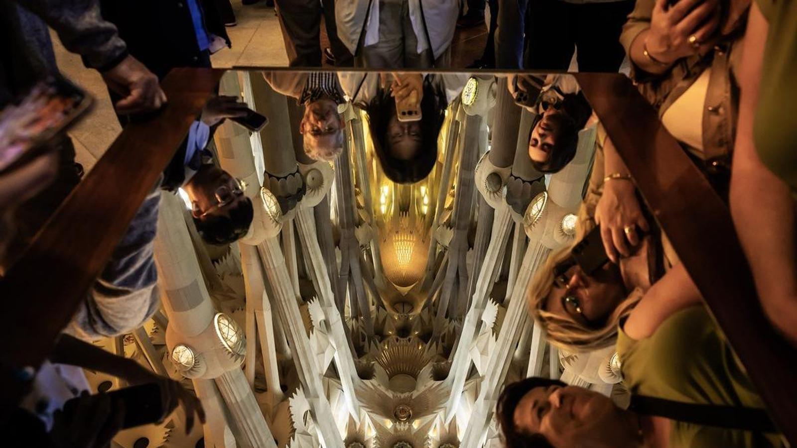 Visitantes reflejados en un espejo en la Sagrada Familia, en Barcelona el 7 de mayo.