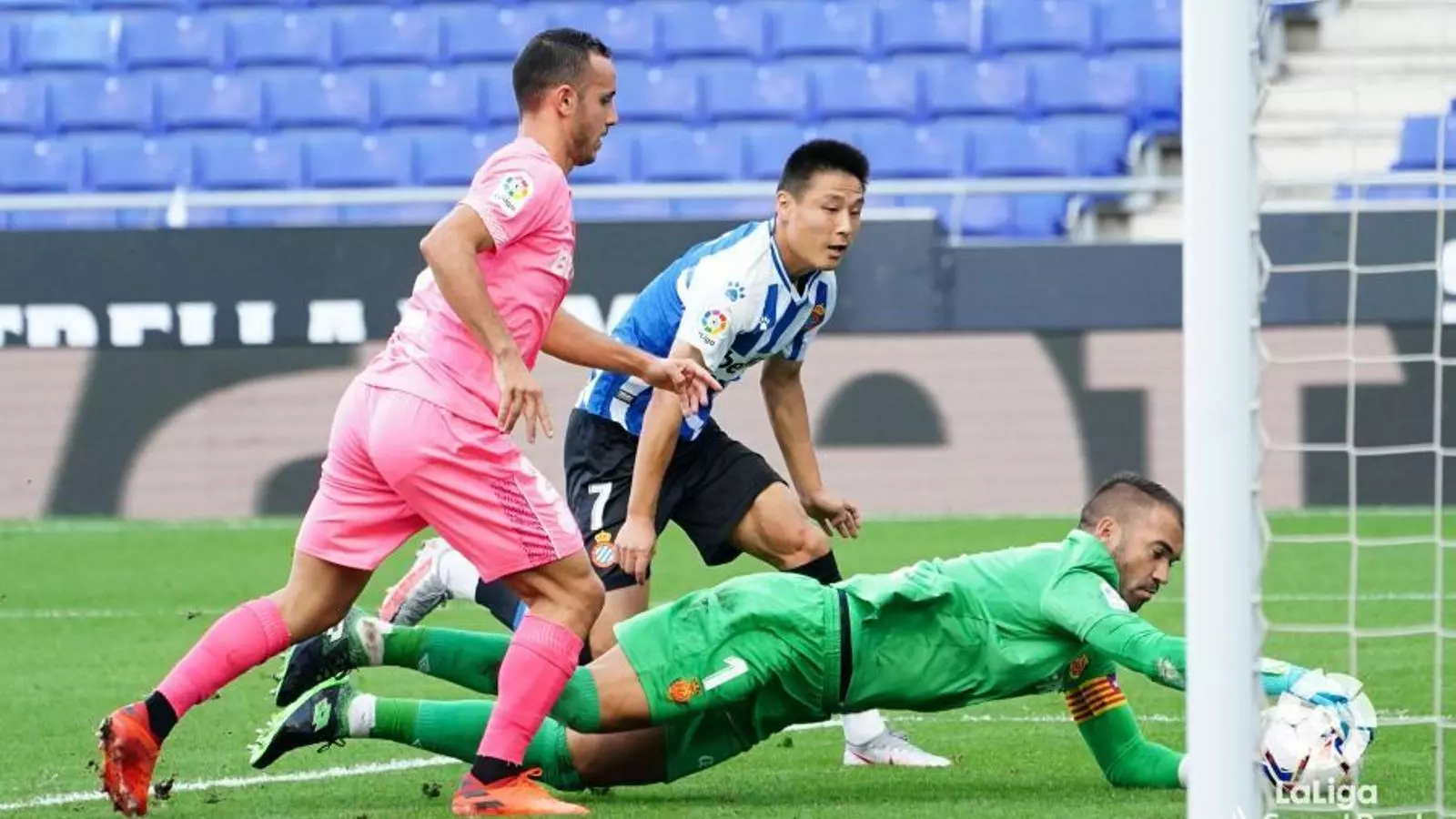 Reina bloca una pilota sota l'atenta mirada de Wu Lei