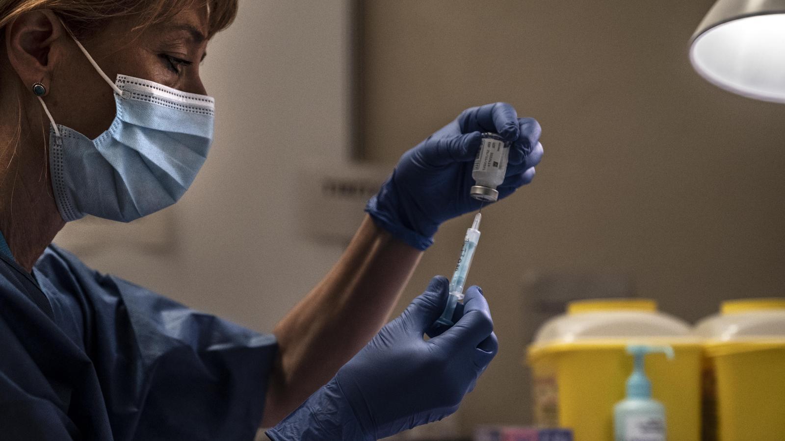 A nurse carries a syringe with a vaccine against covid in the Berlin room of the Camp Nou, enabled for a few weeks as a vaccination point