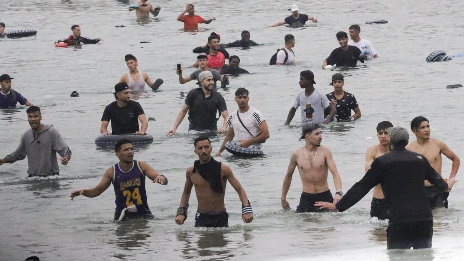 Un grup de joves migrants al costat del pas fronterer de Tarahal, a Ceuta, avui divendres 31 de juliol.