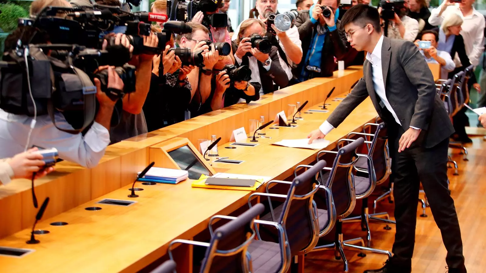 El jove Joshua Wong es prepara per atendre els mitjans de comunicació davant l'atenció de càmeres i fotògrafs, a Berlín