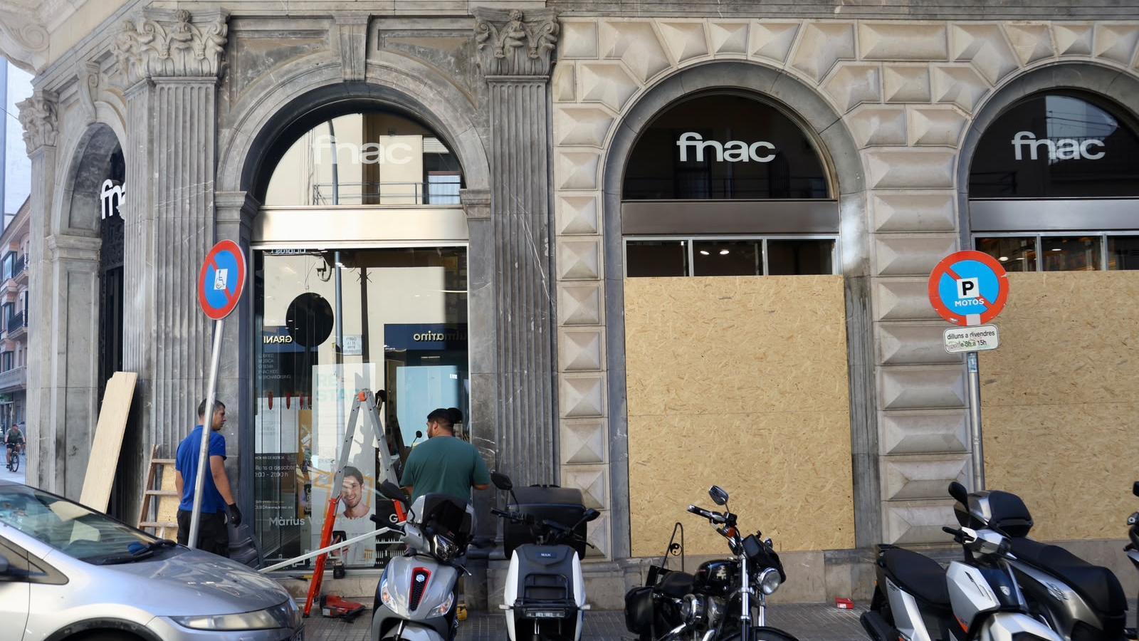 Workers boarding up the shop window of a business in the center of Palma.