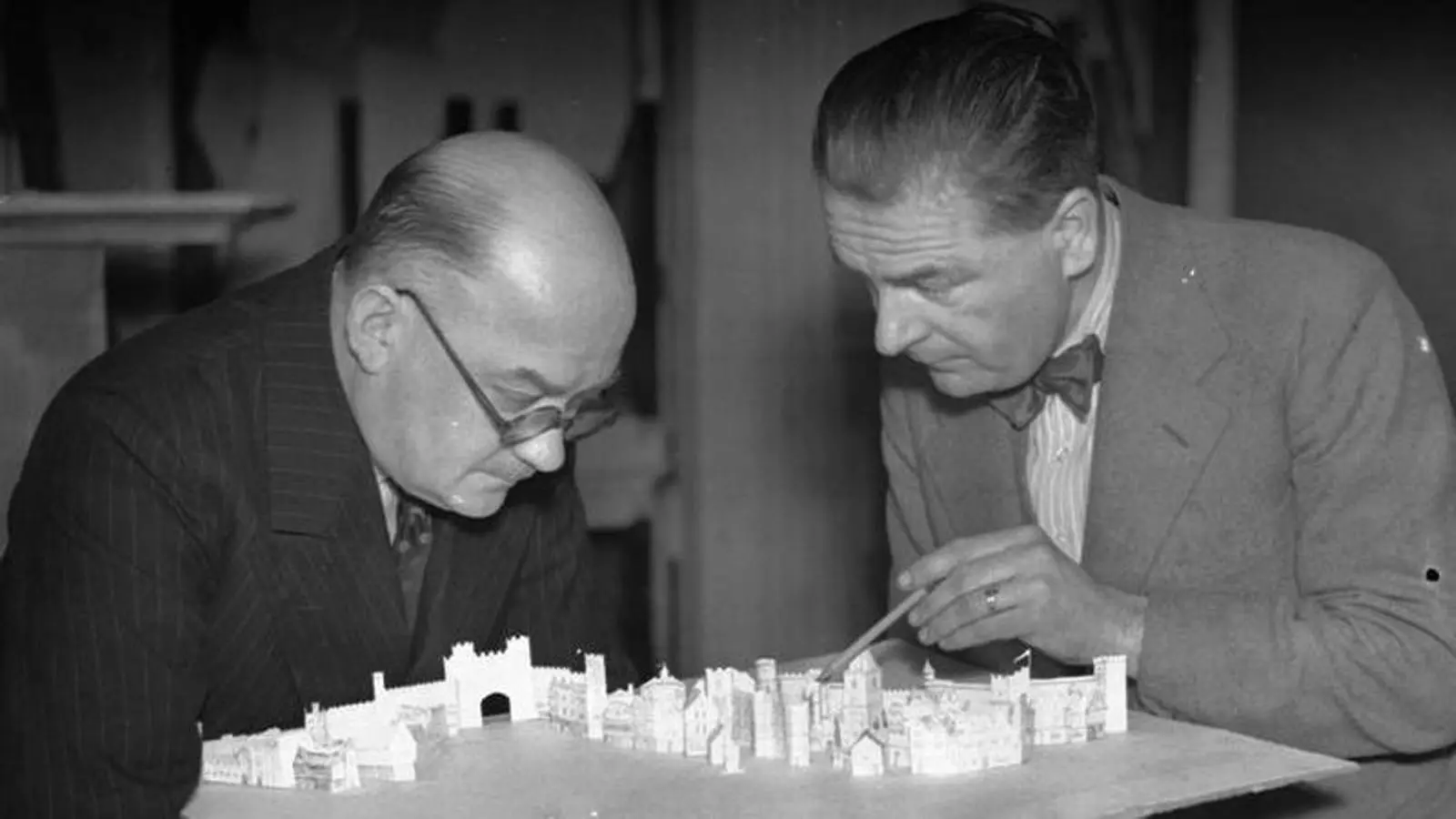 Dos homes discuteixen un projecte en maqueta.