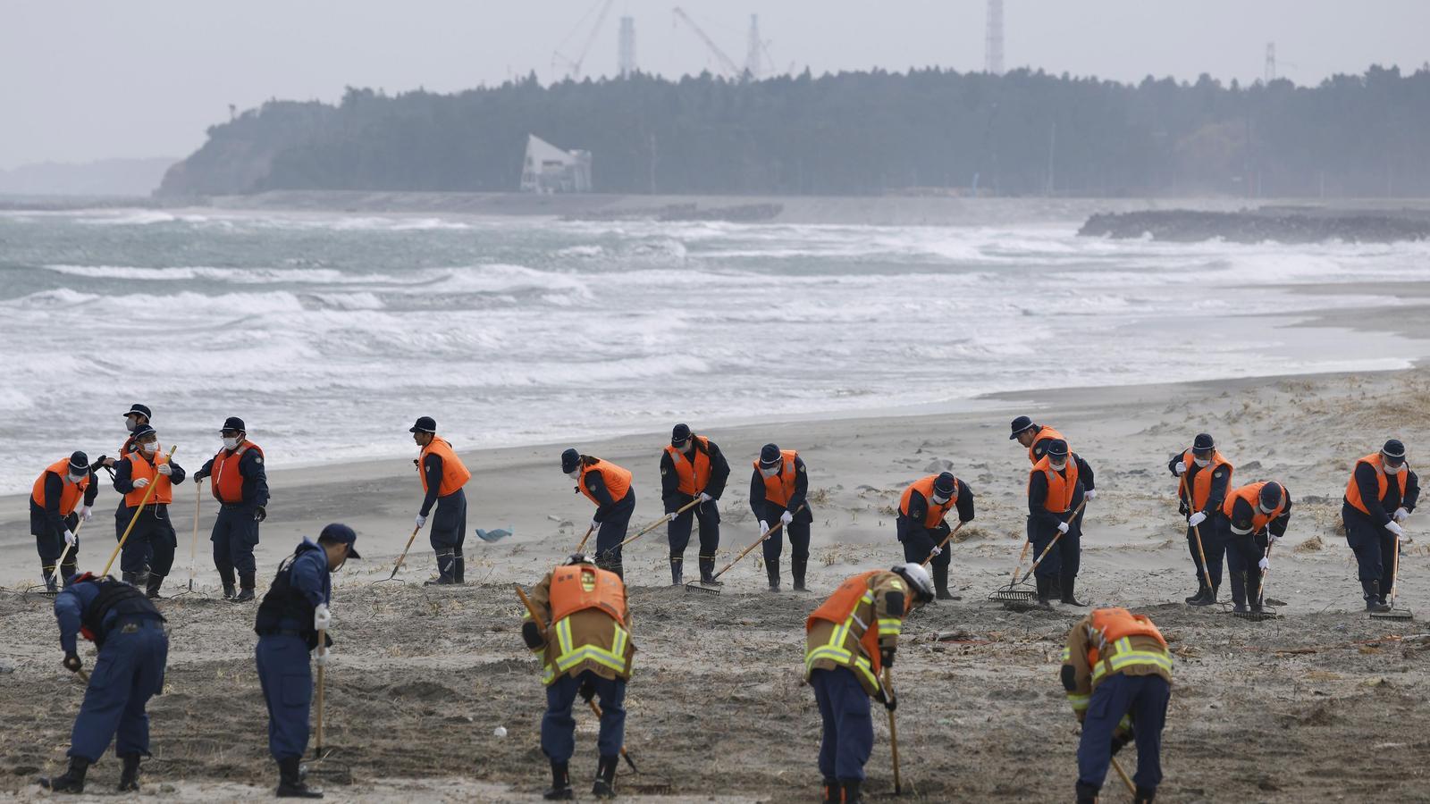 Police officers search the coast of Namie, Fukushima Prefecture, for clues about people who went missing after the 2011 Great East Japan Earthquake triggered a massive tsunami, on March 11, 2025, the 14th anniversary of the disaster.