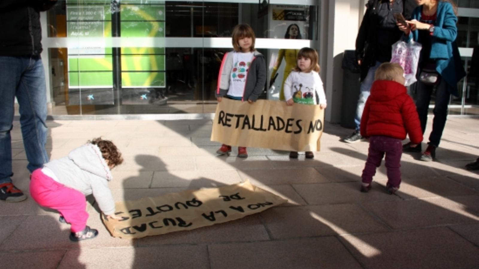 Pares i fills mostrant pancartes en contra del tancament de l'Escola Bressol Gespa a les portes del Rectorat de la UAB.