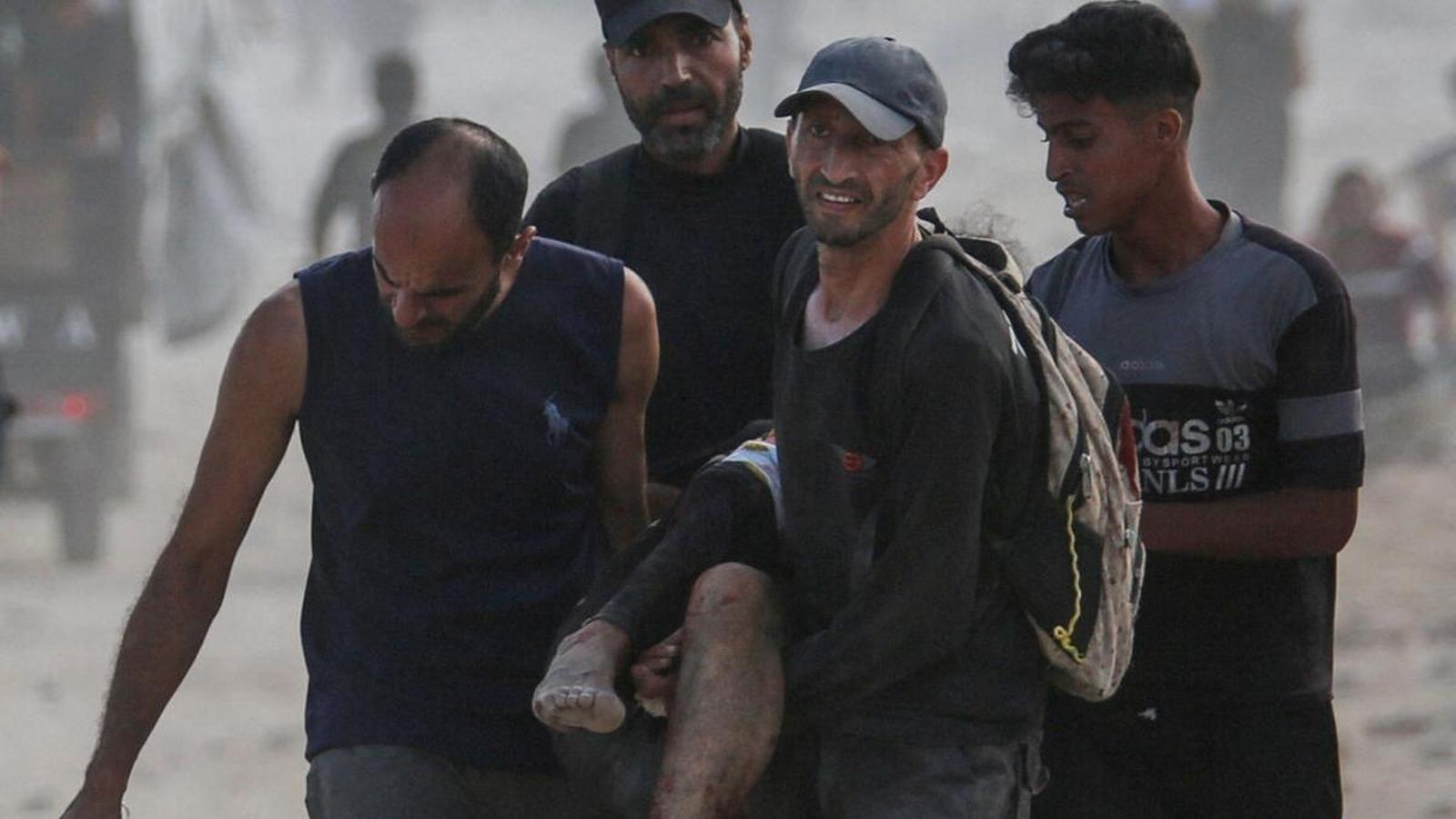 Palestinians carry a person injured by Israeli fire in Gaza.