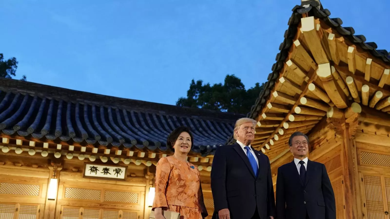 Trump, entre la primera dama sud-coreana Kim Jung-sook i el president, Moon Jae-in, a l'arribar a Seül