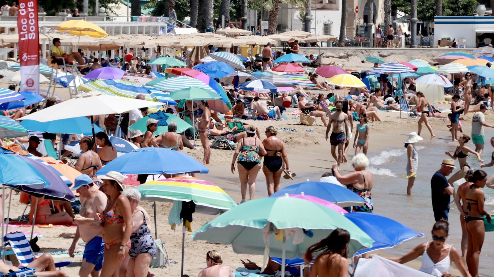 Una playa de Sitges con mucha afluencia de gente.