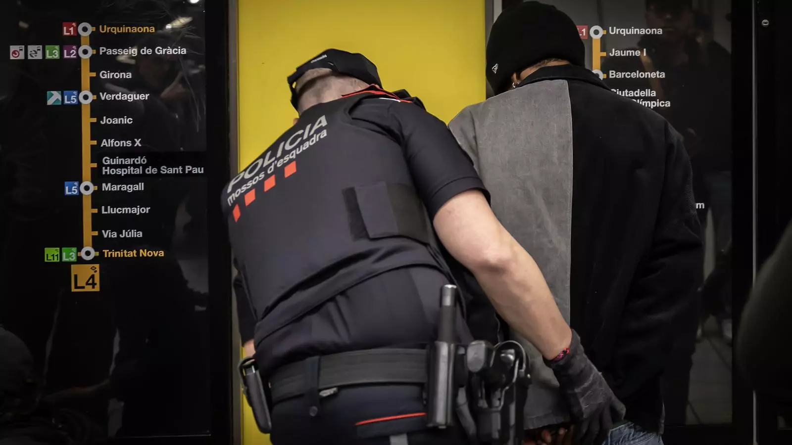 Un agent dels Mossos escorcollant una persona al metro de Barcelona en una imatge d'arxiu.
