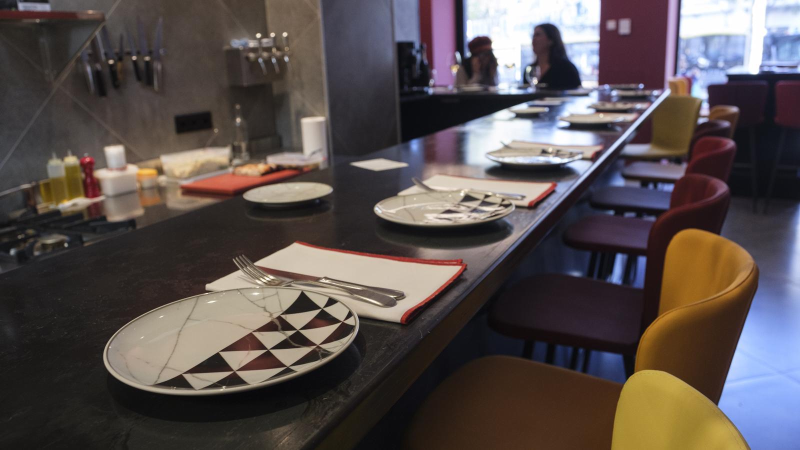 The high bar, prepared for the lunch menu, with cloth napkins, colorful stools