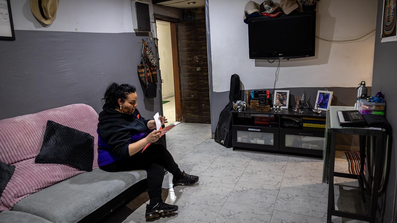 Maika Granados leyendo en el comedor de su piso que ha pasado de un fondo buitre a ser propiedad de la cooperativa Les Juntes.