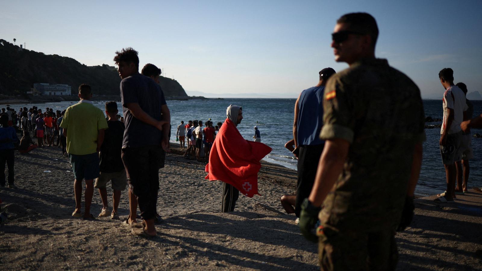 Migrantes en la playa de Ceuta después de un intento masivo de entrada desde Marruecos.