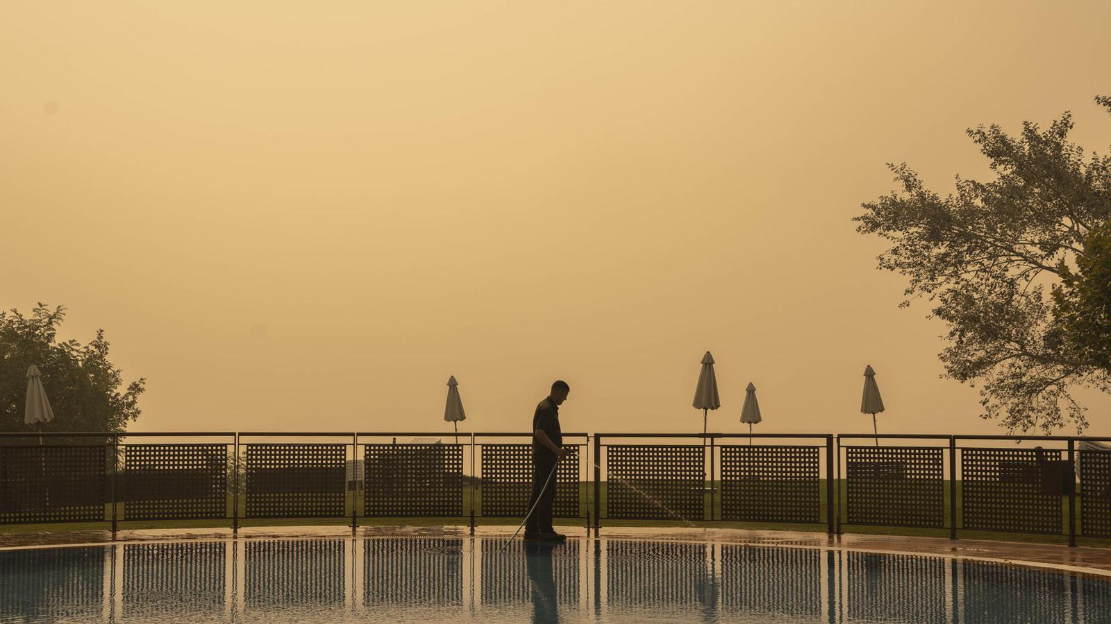 A smoky sky covers a worker at the Monterrei Parador (Ourense), affected by a forest fire.