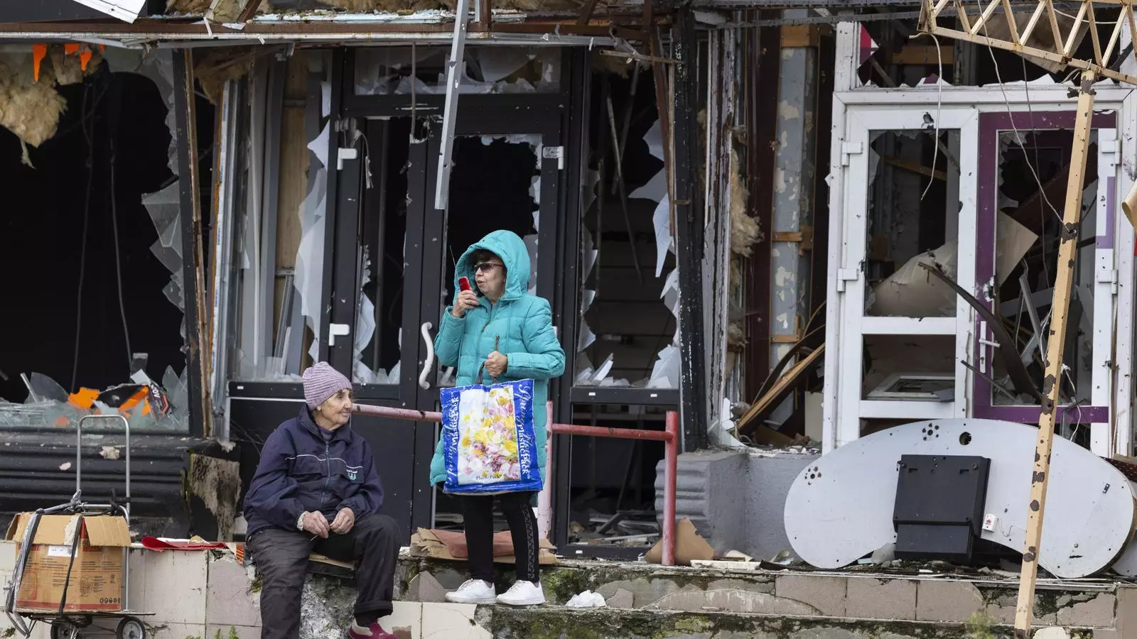 Dos mujeres ante un edificio destruido, a Izium, esperando que llegue la ayuda humanitaria