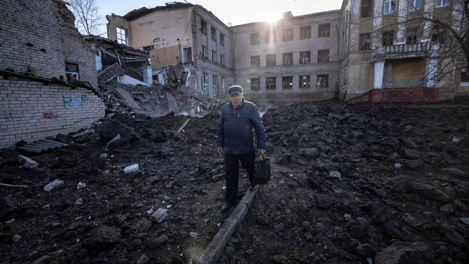 Un home camina prop d'una escola danyada, al costat d'un edifici de policia a Kramatorsk, a la regió de Donbas