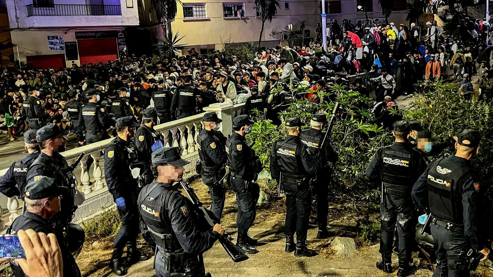 La policía ha comenzado el traslado de migrantes al campamento del puerto de Ceuta.