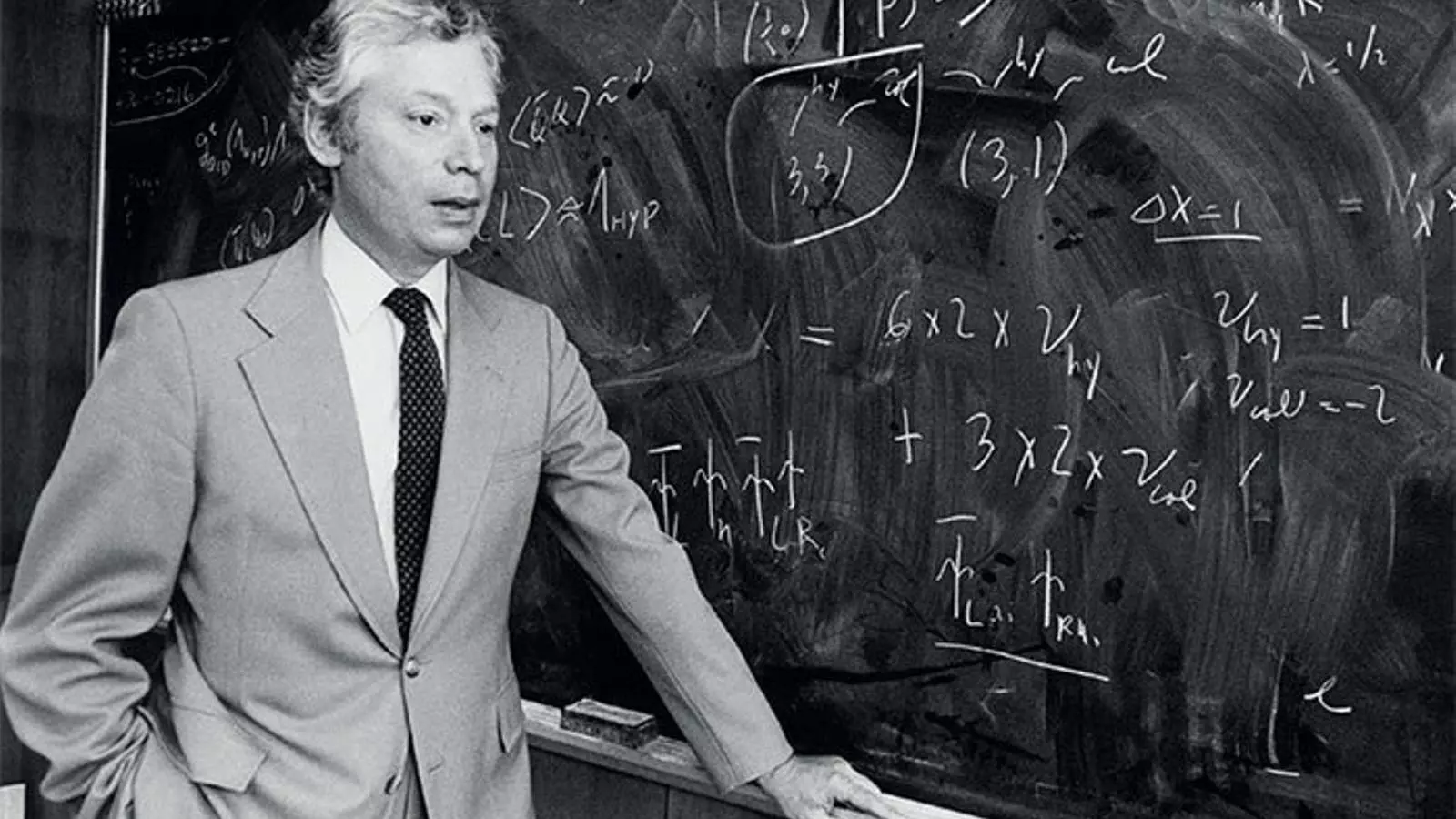 Steven Weinberg al davant d’una pissarra plena d’equacions.