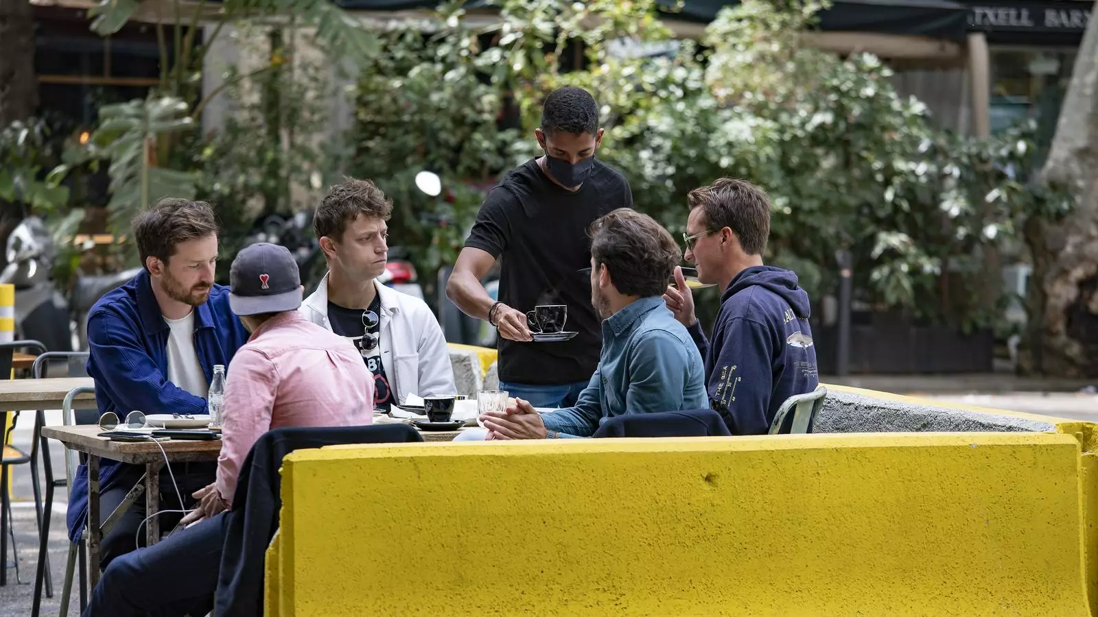 Un camarero sirviendo los clientes a la terraza de un bar de Barcelona.