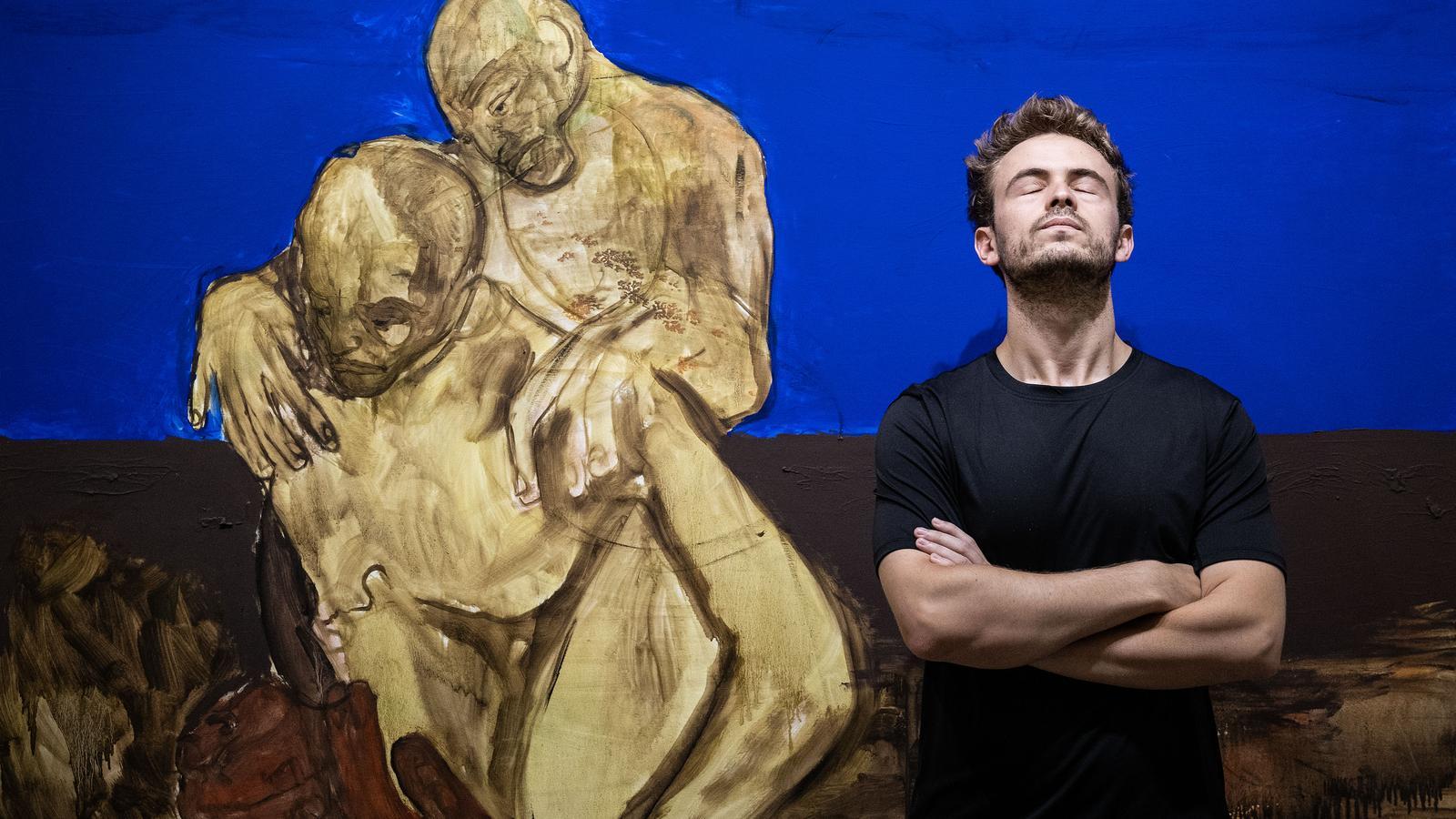 The artist José Luis Barquero at the Mayoral Gallery with the painting 'Burden in Red Hands'