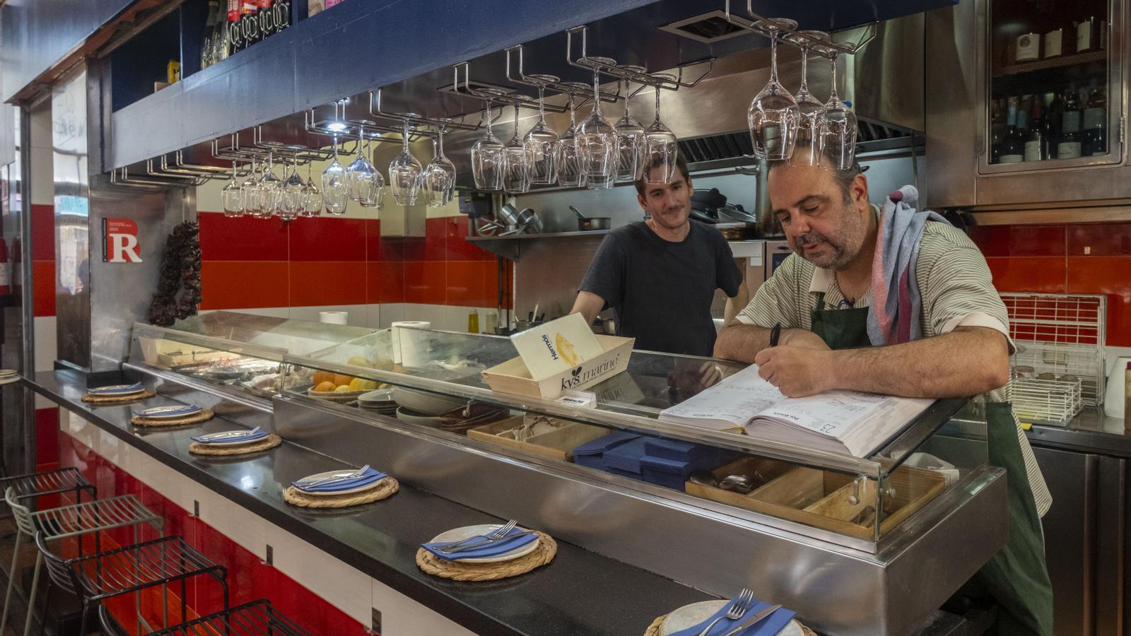 Alexis Peñalver and Alejandro, taking note of the orders of the last few days; Saturday is the last day open