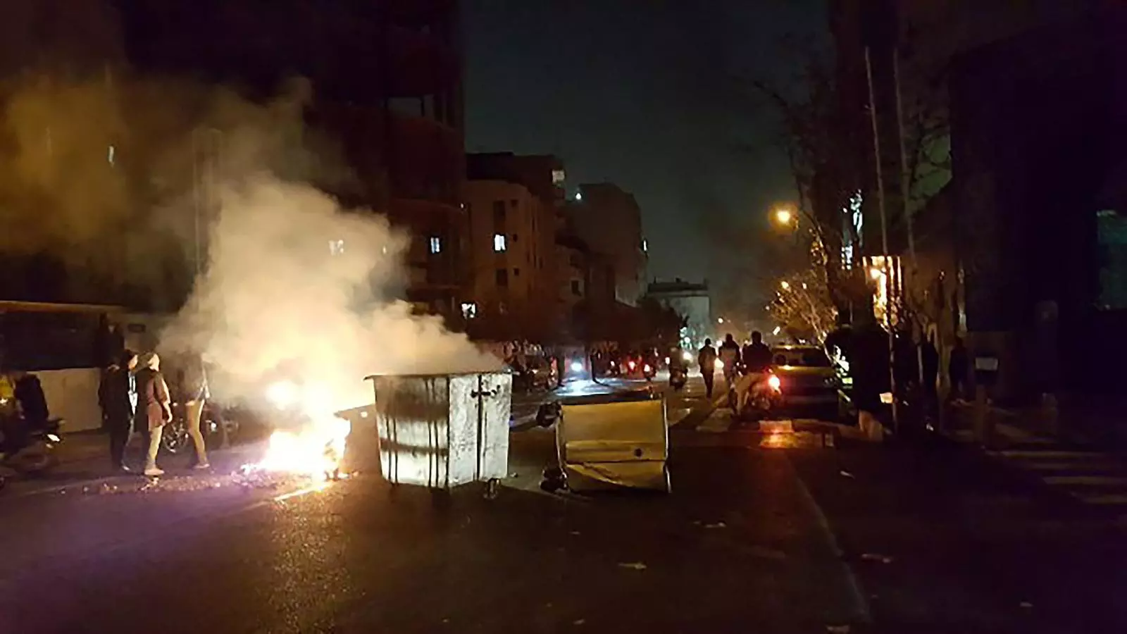 Diversos contenidors cremant en un carrer de la capital iraniana, Teheran.