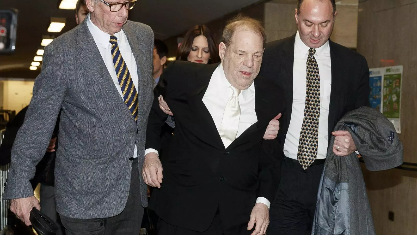 El productor Harvey Weinstein amb dos membres del seu equip que l'ajuden a caminar
