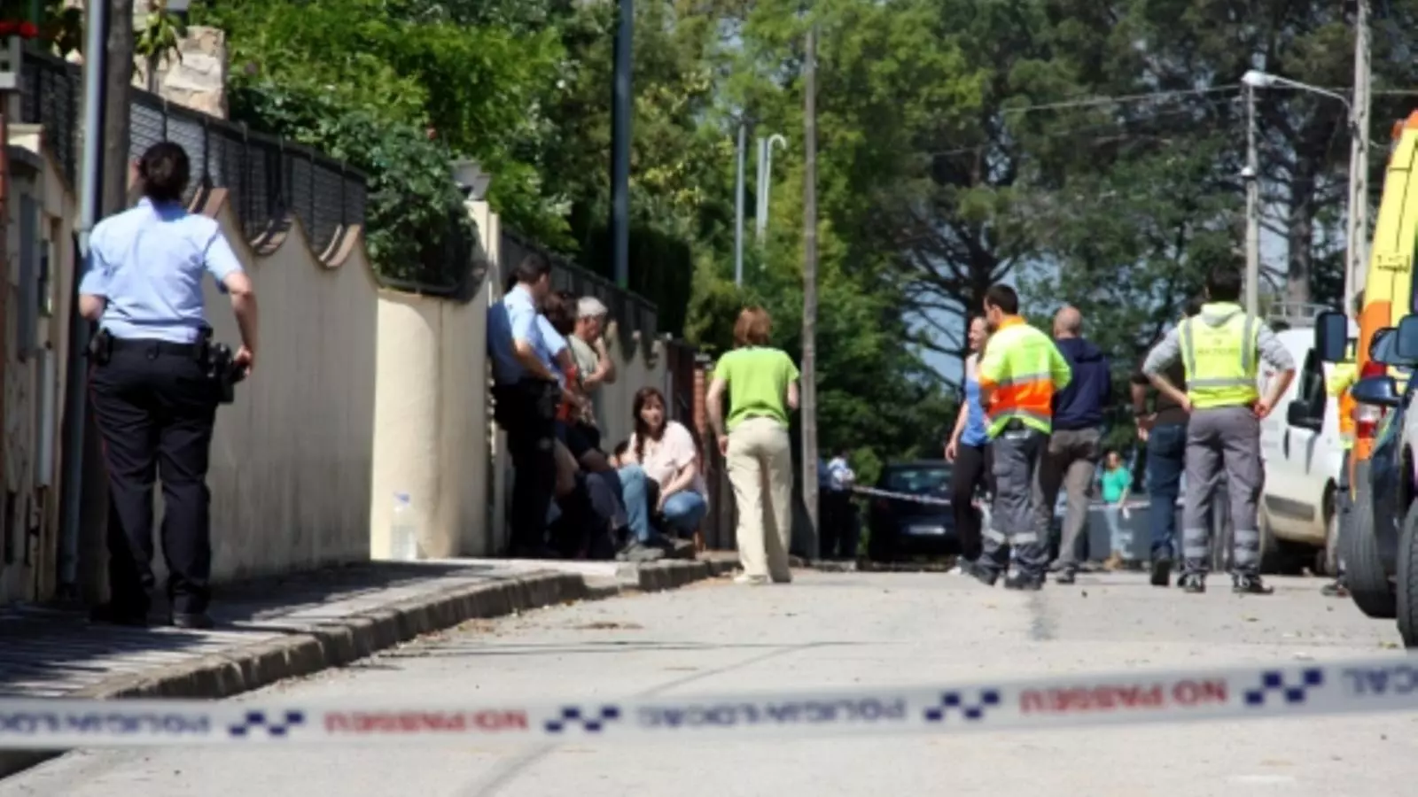 Familiars de les víctimes, policia i personal mèdic, davant les portes del domicili on ha passat el crim, a la urbanització Llac del Cigne de Caldes de Malavella / ACN