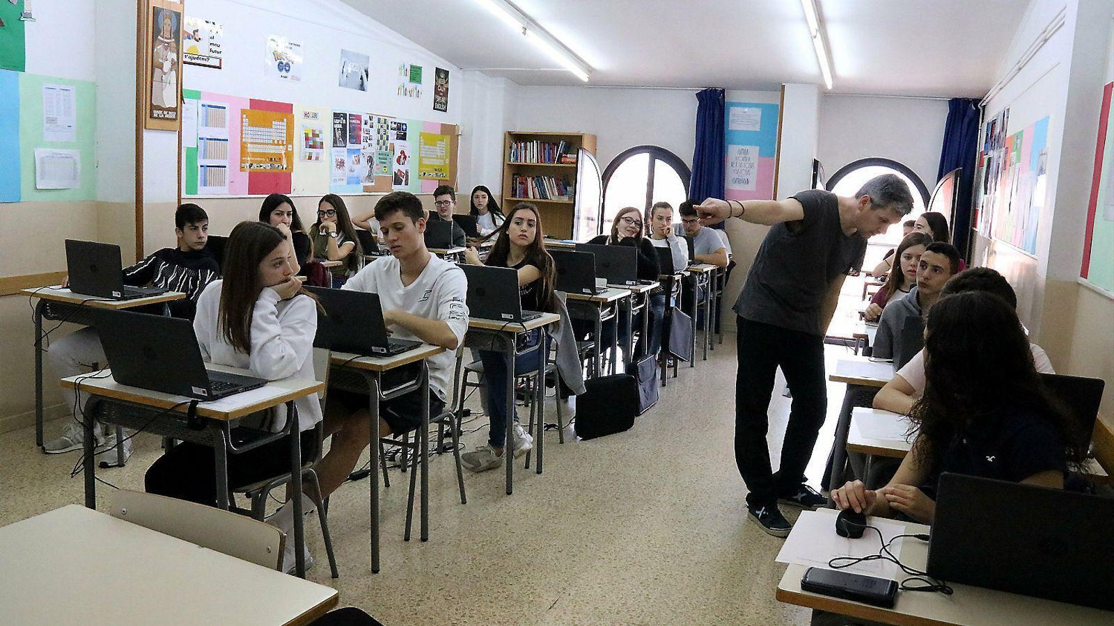 Un professor donant indicacions als alumnes en una sessió d'exàmens PISA