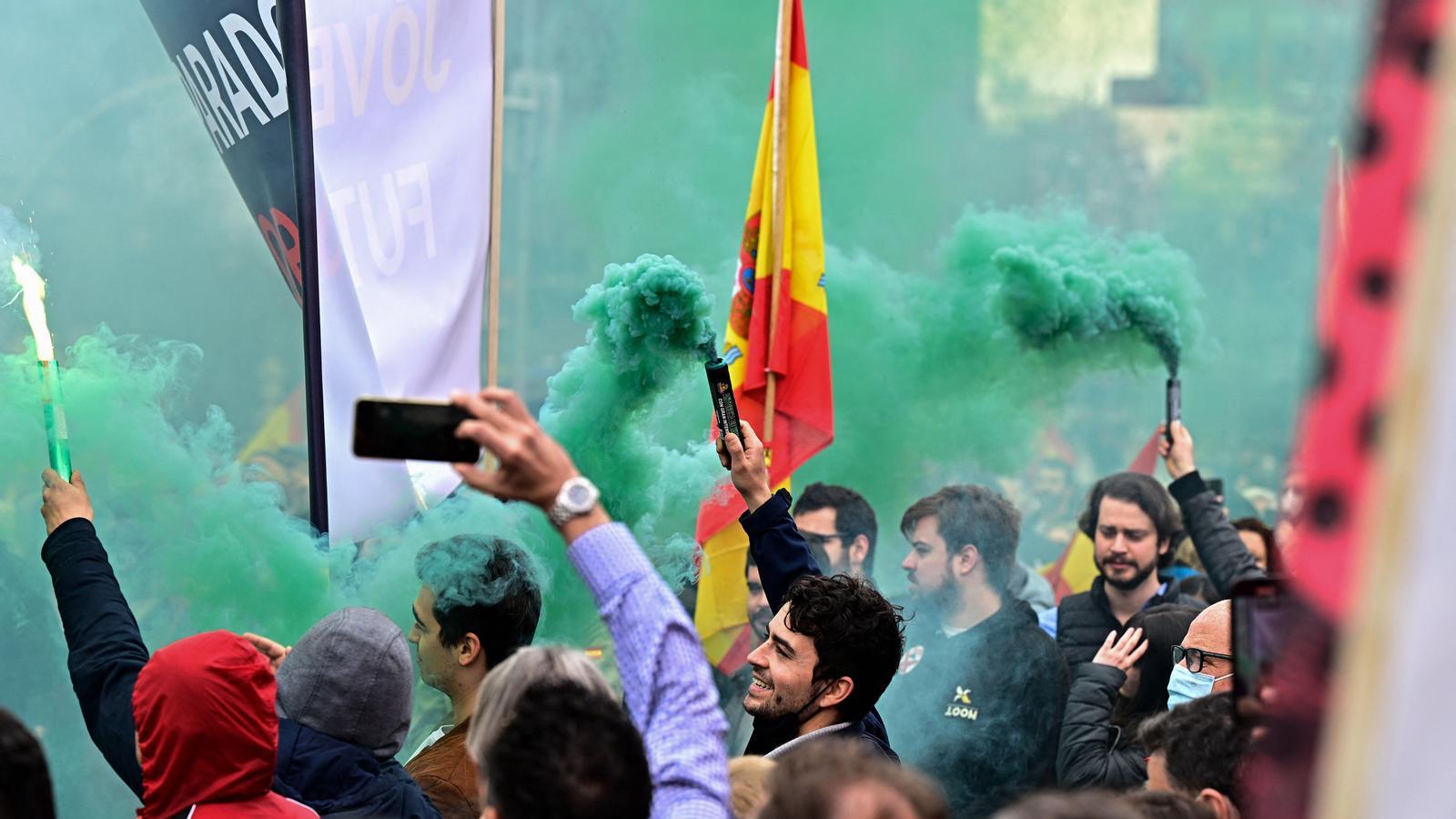 Manifestants de Vox con banderas españolas y vengales de humo, este sábado en Madrid.