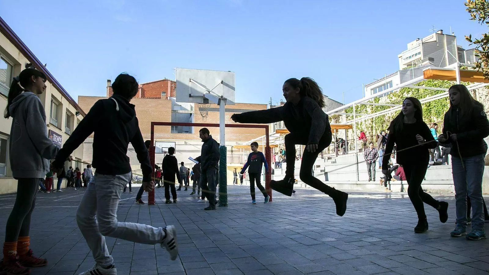Alumnes de primer i segon d’ESO fan educació física al pati d’una escola.