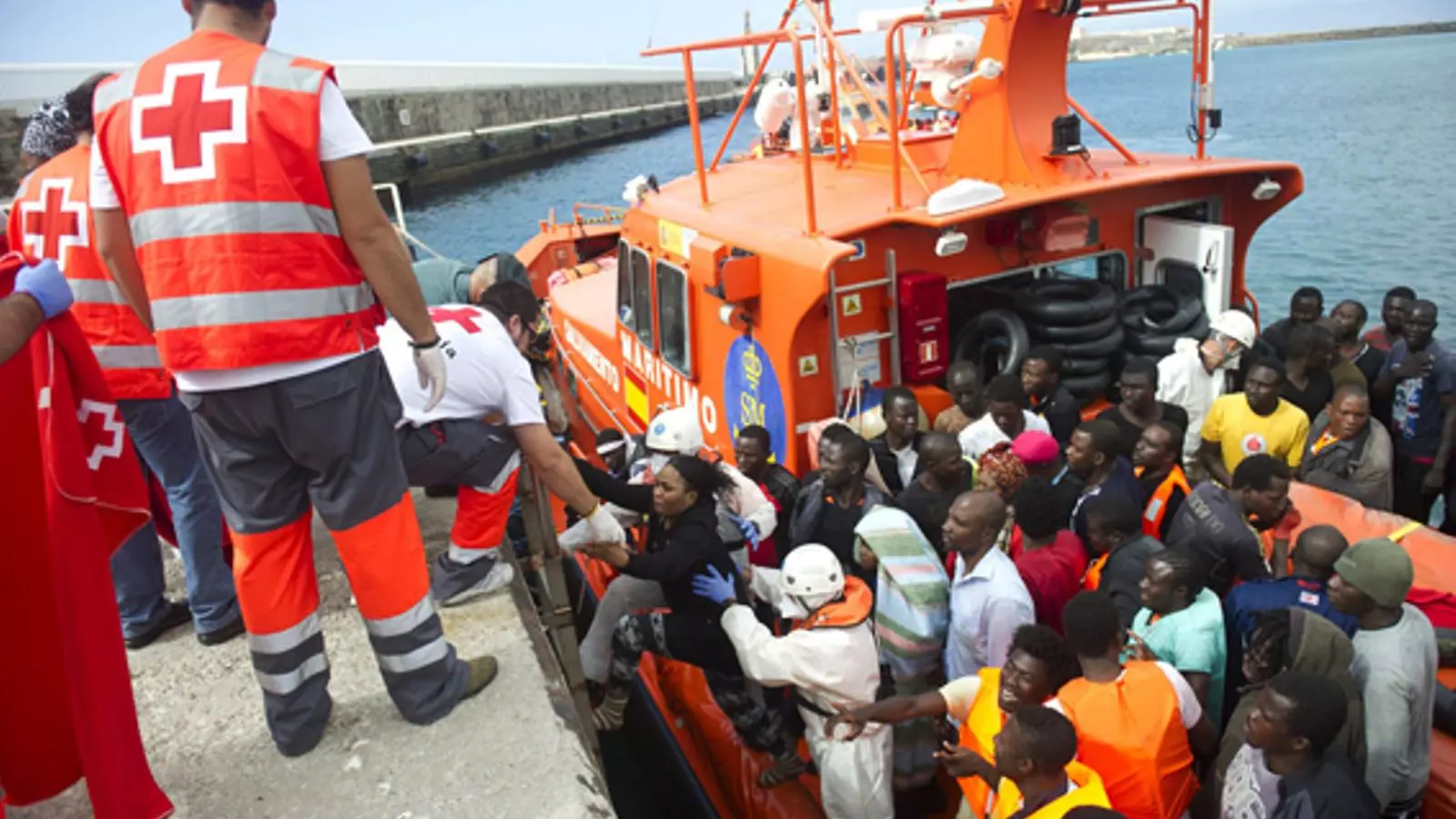 Membres del servei d'emergència de la Creu Roja i la Guàrdia Civil ajuden als immigrants a desembarcar d'un vaixell de la guàrdia costanera. AFP Photo / Marcos Moreno