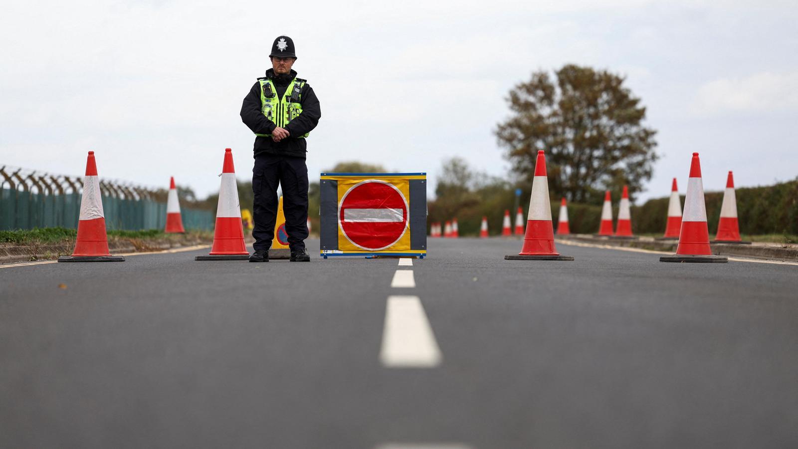 Un agente de policía hace guardia en un corte de carretera a las afueras de la base aérea de la RAF de Fairford, en Gloucestershire, después de que la policía declarara un incidente grave en la base a raíz de la detención de varios hombres sospechosos de delitos tipificados en la Ley de Explosivos, el domingo 27 de septiembre de 2026.