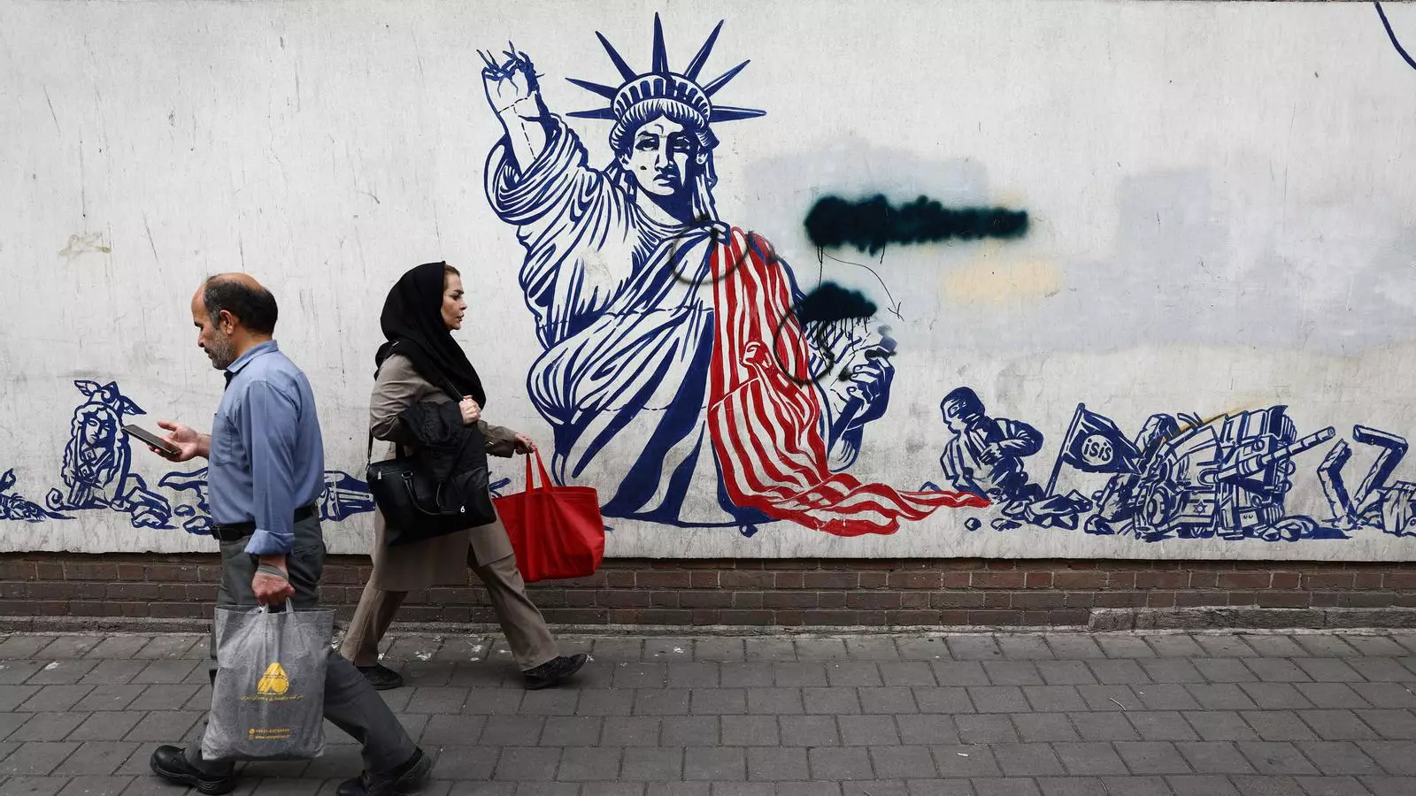 Gent camina per davant d'un mural antiamericà durant l'alto el foc entre els EUA i l'Iran, a Teheran