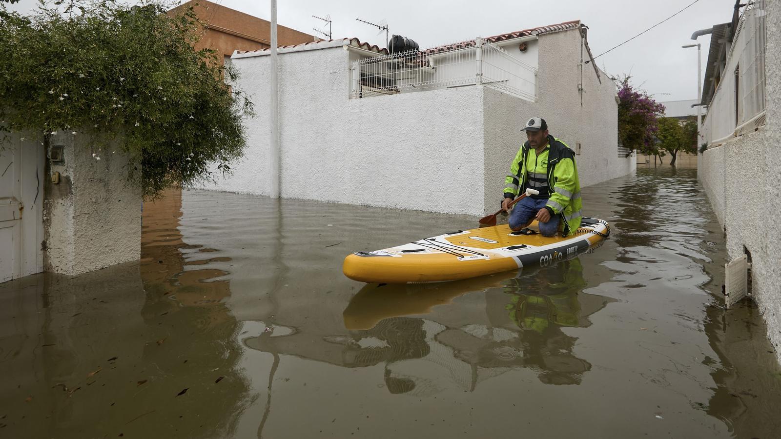 A man on a surfboard in Gandia, in the Valencian Country, an area affected by the 'Adam' DANA