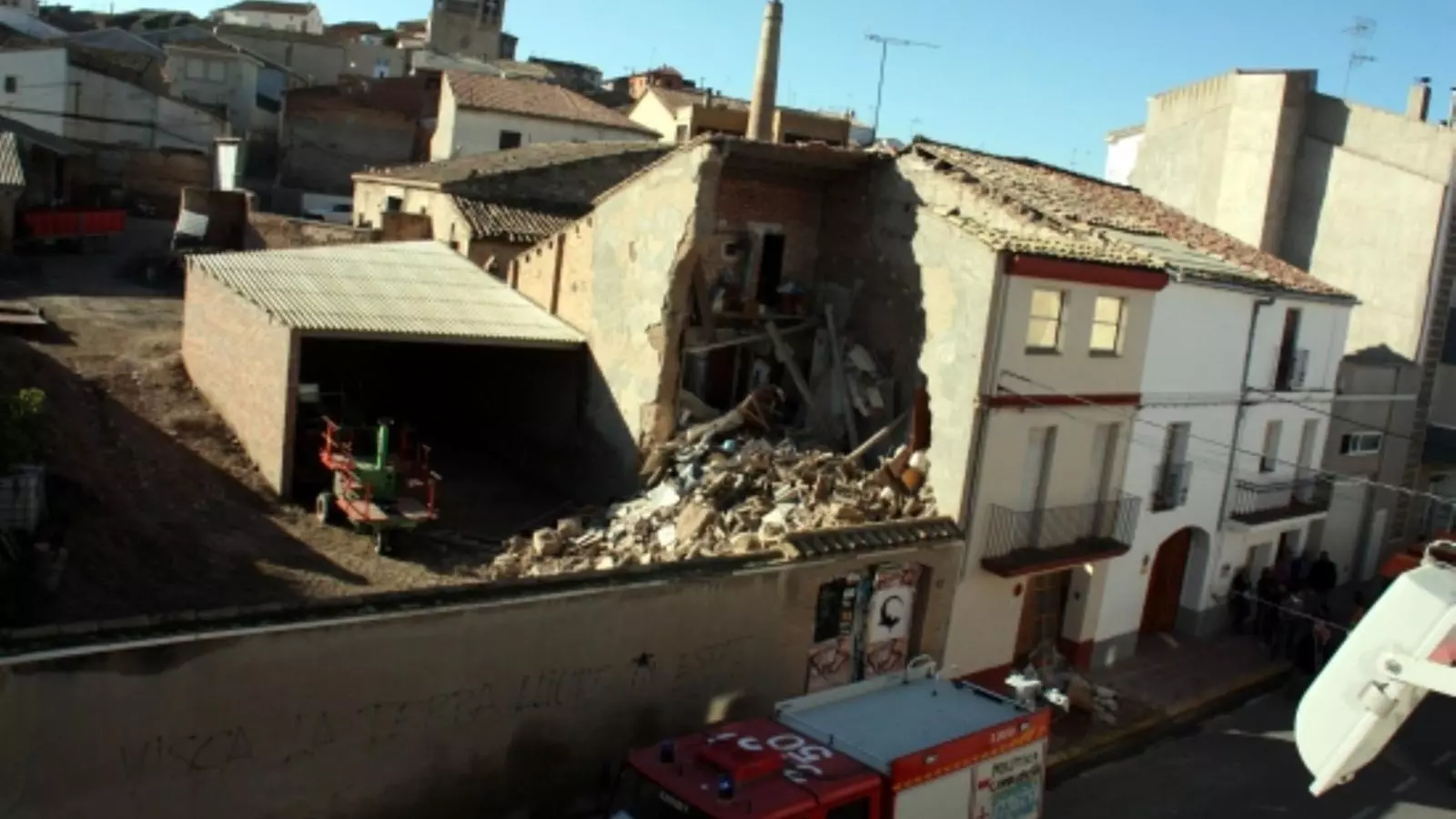Camions dels Bombers al davant de la casa parcialment esfondrada a Miralcamp / ACN
